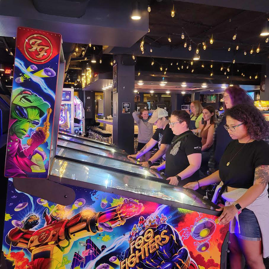 Belles and chimes members playing pinball at Double Tap in Madison