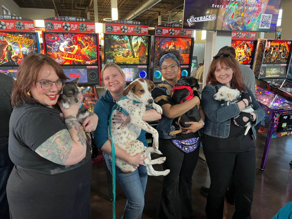 Top four winners for the Metallica launch party holding puppies